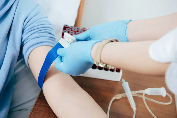 Teilansicht des Arztes mit Tourniquet für Bluttest im Krankenhaus — Stockfoto