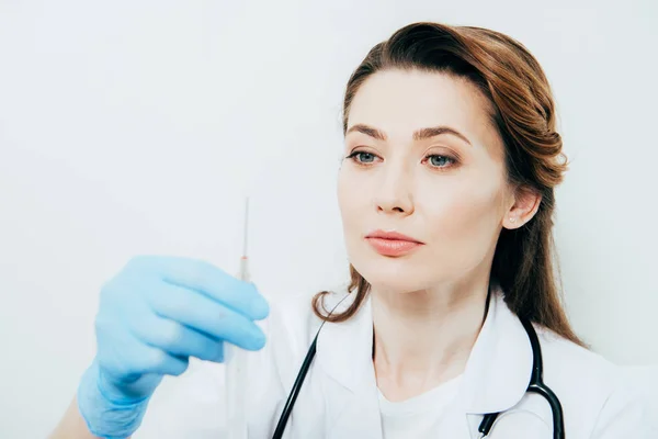 Doctor en bata blanca y guante de látex con jeringa aislada en blanco - foto de stock