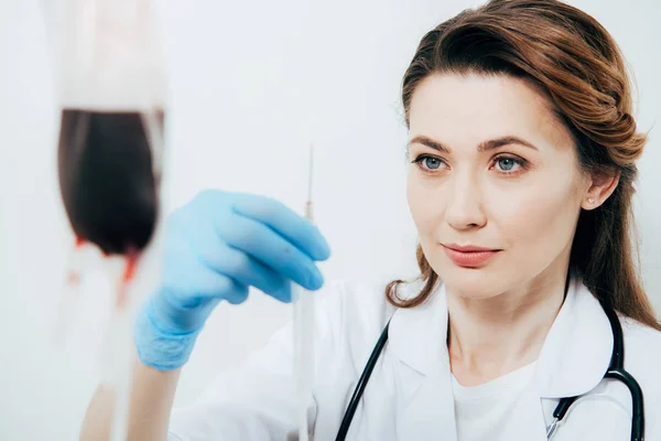 Doctor in white coat and latex glove holding syringe in hospital — Stock Photo