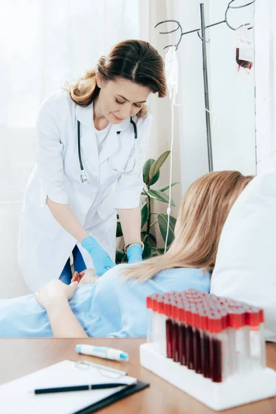 Doctor in white coat and donor donating blood in hospital — Stock Photo