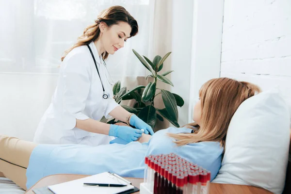 Doctor in white coat preparing patient for injection — Stock Photo