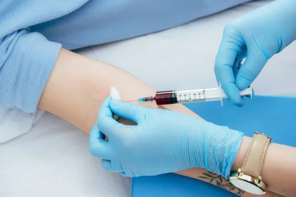 Vista recortada de donante y médico con jeringa obtención de muestra de sangre - foto de stock