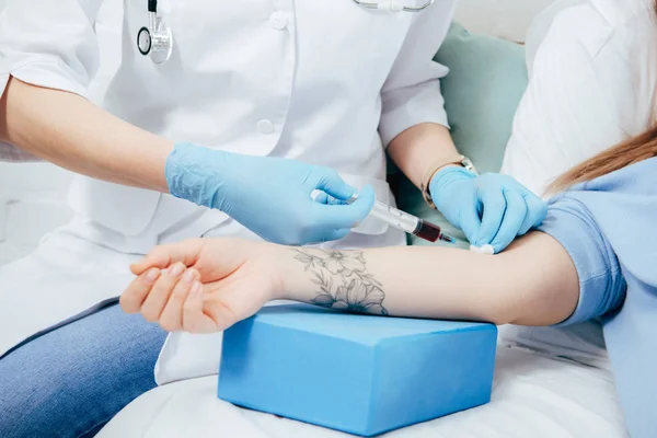 Vista ritagliata del donatore e del medico con siringa per ottenere un campione di sangue — Foto stock