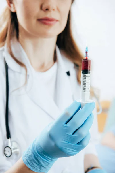 Teilansicht des Arztes im weißen Kittel mit Spritze und Blutprobe — Stockfoto