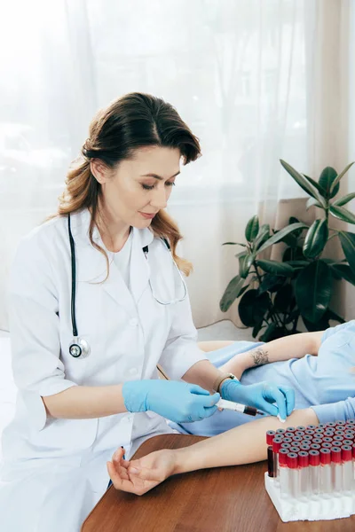 Vista ritagliata del donatore e del medico con siringa per ottenere un campione di sangue — Foto stock