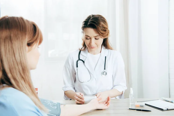 Cropped view of patient and doctor measuring blood pressure — Stock Photo