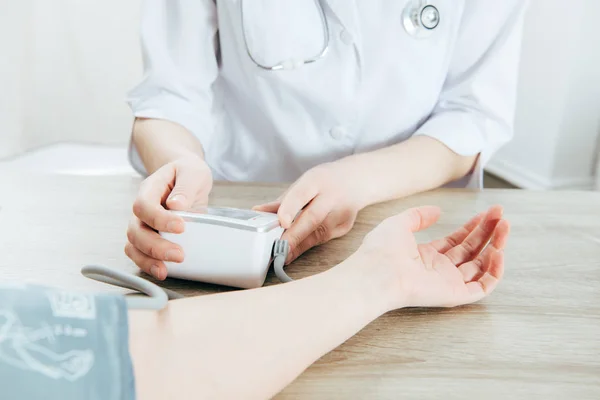 Ausgeschnittene Ansicht von Patient und Arzt zur Blutdruckmessung — Stockfoto