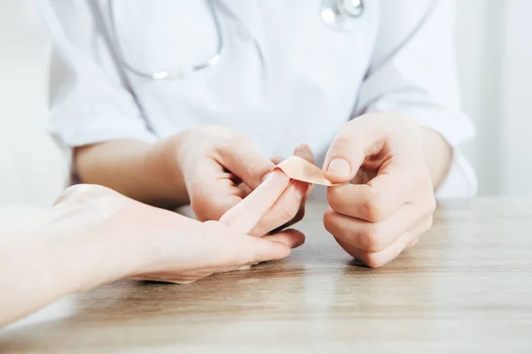 Partial view of donor and doctor using adhesive bandage — Stock Photo