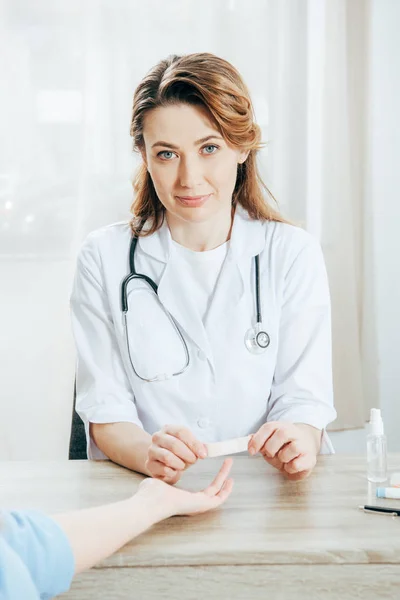 Partial view of donor and doctor using adhesive bandage — Stock Photo