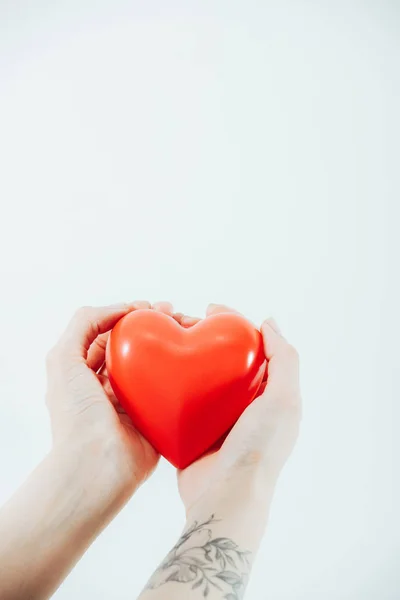 Vista ritagliata della donna che tiene il cuore di plastica isolato su bianco — Foto stock