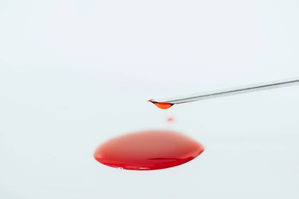 Игла шприца и пятна крови изолированы на белом — стоковое фото
