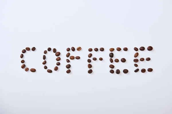 Vista dall'alto di lettering caffè fatto di chicchi di caffè su sfondo bianco — Foto stock