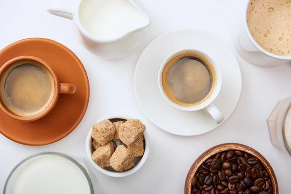 Vista dall'alto del caffè con latte e zucchero di canna su sfondo bianco — Foto stock