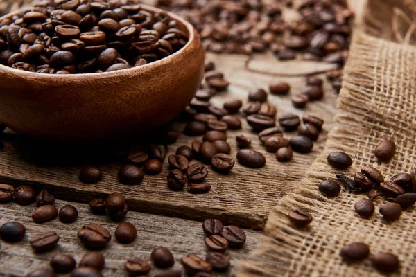 Vista da vicino di chicchi di caffè su ciotola su sfondo di legno — Foto stock