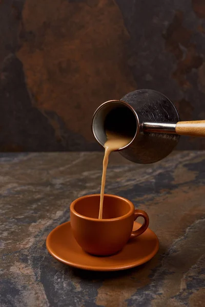 Verser le café de cezve dans une tasse sur la surface du marbre — Photo de stock