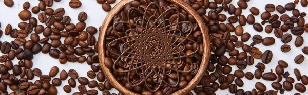 Tiro panorâmico de saborosos grãos torrados de café em tigela de madeira no fundo branco — Fotografia de Stock