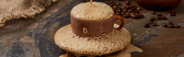 Plan panoramique de mousse de café fraîche coulant de la tasse sur la soucoupe sur la surface du marbre — Photo de stock