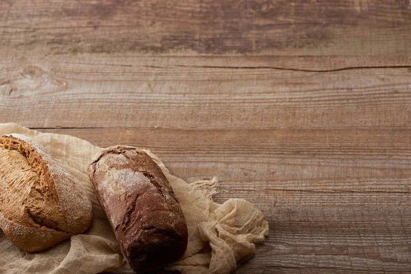 Свежий хлеб хлеба на ткани на деревянном столе — стоковое фото