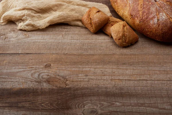 Frisches Brot und Brötchen in Tuchnähe auf Holztisch mit Kopierraum — Stockfoto