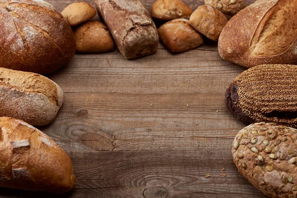 Pains frais cuits au four sur table rustique en bois avec espace de copie — Photo de stock