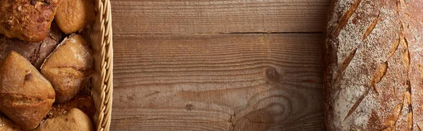 Vista dall'alto pane e focacce in cesto di vimini su tavolo di legno, colpo panoramico — Foto stock