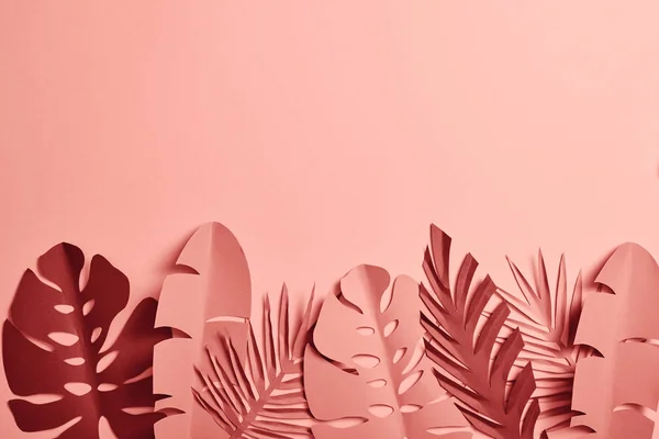Vue du dessus des feuilles de palmier coupées en papier sur fond rose — Photo de stock