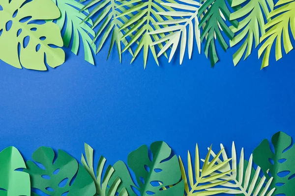 Top view of green exotic leaves on blue background with copy space — Stock Photo