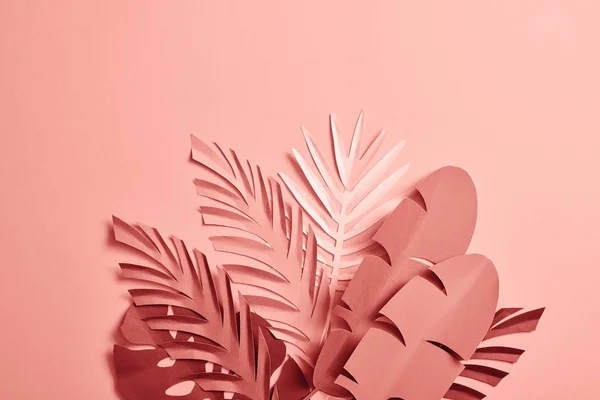 Bunch of paper cut palm leaves on pink background — Stock Photo