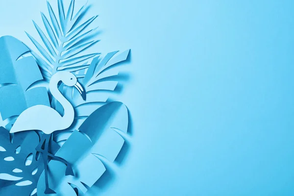 Vista superior de hojas de palma cortadas en papel minimalista azul sobre fondo azul con espacio para copiar - foto de stock