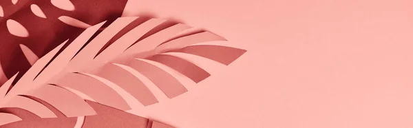 Tiro panorâmico de folhas de palma de corte de papel no fundo rosa — Fotografia de Stock