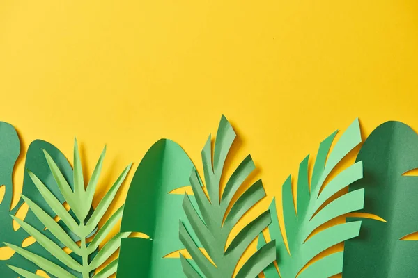 Vista superior de folhas de palma verde exóticas de corte de papel no fundo amarelo com espaço de cópia — Fotografia de Stock