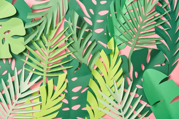 Vista dall'alto di foglie di palma verde sparse su sfondo rosa con spazio copia — Foto stock