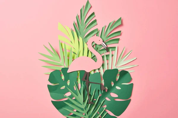 Top view of paper cut flamingos on green palm leaves on pink background — Stock Photo