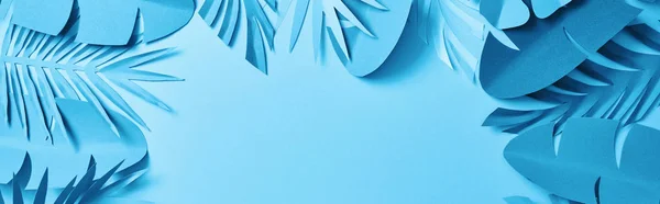 Top view of blue minimalistic paper cut palm leaves on blue background with copy space, panoramic shot — Stock Photo