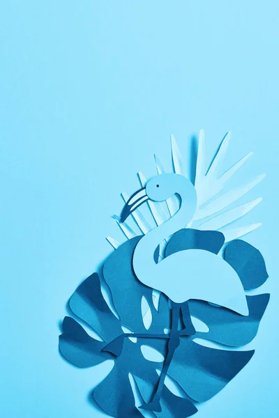 Top view of blue minimalistic paper cut palm leaves and flamingo on blue background with copy space — Stock Photo