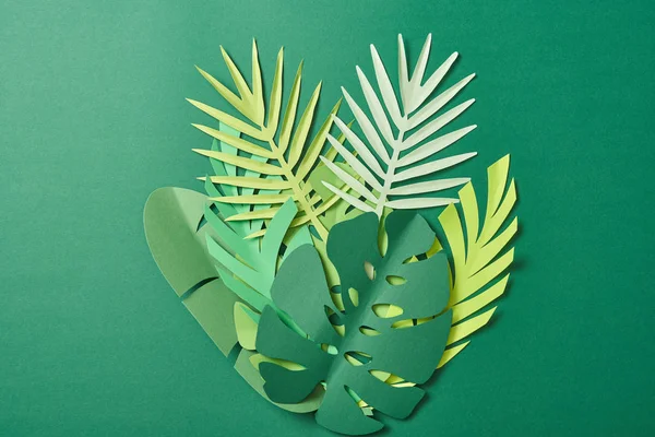 Top view of tropical paper cut palm leaves on green background with copy space — Stock Photo