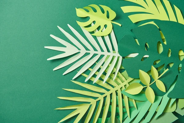 Draufsicht auf tropische Papier geschnittene Palmenblätter auf grünem Hintergrund mit Kopierraum — Stockfoto
