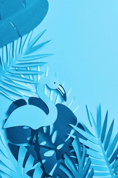 Top view of blue minimalistic paper cut palm leaves and flamingo on blue background with copy space — Stock Photo