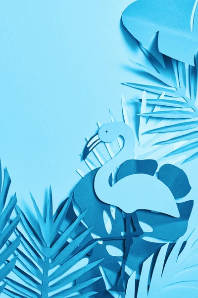 Vista superior de papel minimalista azul cortar folhas de palma e flamingo no fundo azul com espaço de cópia — Fotografia de Stock