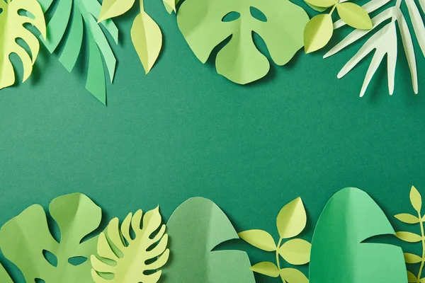 Top view of exotic paper cut palm leaves on green background with copy space — Stock Photo