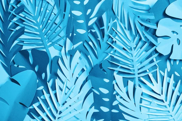 Seamless pattern of blue exotic paper cut palm leaves on blue background with copy space — Stock Photo