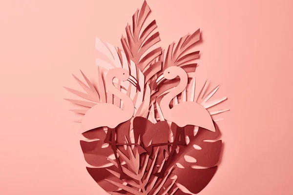Вид сверху на розовую экзотическую бумагу срезают пальмовые листья и фламинго на розовом фоне — стоковое фото