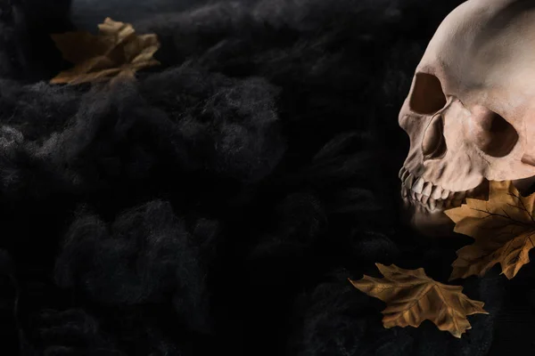 Effrayant crâne humain avec des feuilles jaunes dans les nuages noirs, décoration d'Halloween — Photo de stock