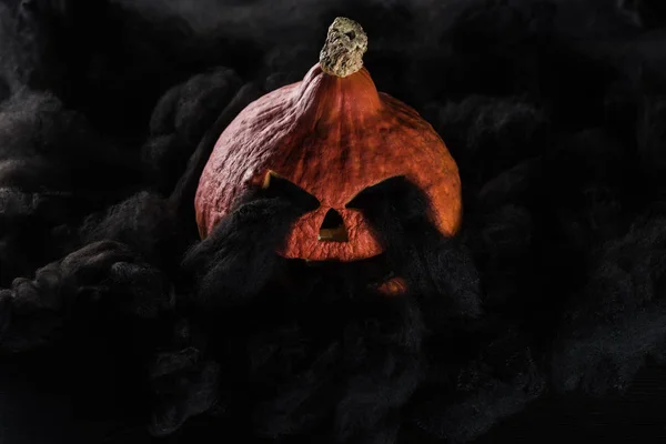 Fantasmagorique sculpté citrouille Halloween avec des nuages noirs — Photo de stock