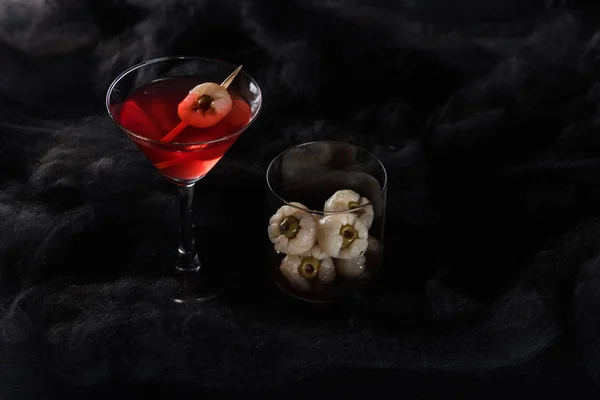 Red decorated Halloween cocktail in black clouds — Stock Photo