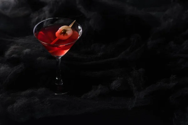 Red decorated Halloween cocktail in black clouds — Stock Photo