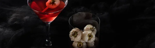 Panoramic shot of red decorated Halloween cocktail in black clouds — Stock Photo