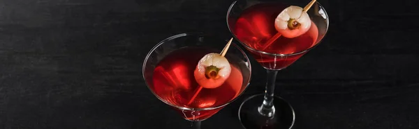 Panoramic shot of red decorated Halloween cocktails on black background — Stock Photo