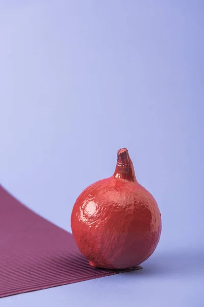 Zucca dipinta di colore rosso su sfondo viola e viola — Foto stock