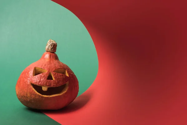 Gruseliger Halloween-Kürbis auf rotem und grünem Hintergrund — Stockfoto